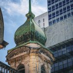 Edifício de São Paulo que combina elementos arquitetônicos históricos e modernos, com uma cúpula ornamentada em destaque.