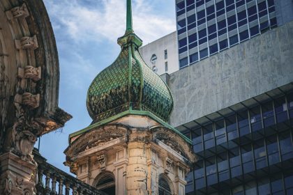 Edifício de São Paulo que combina elementos arquitetônicos históricos e modernos, com uma cúpula ornamentada em destaque.